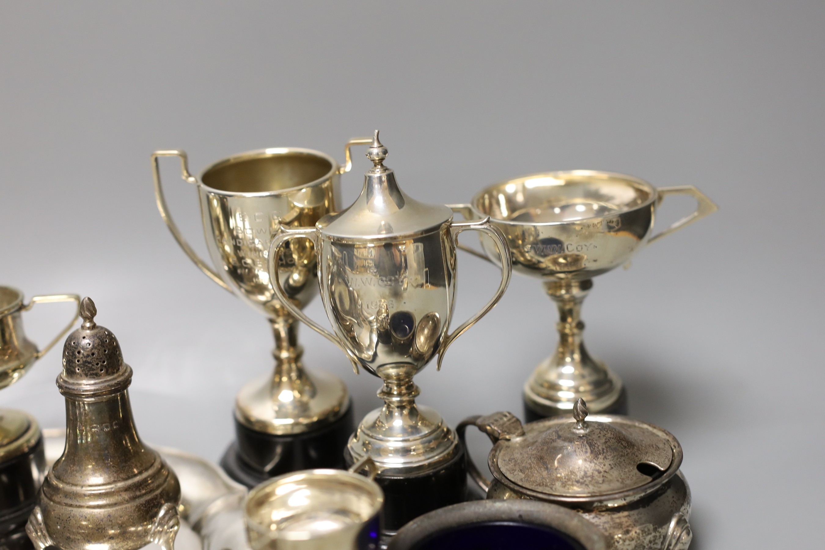 A George V silver salver, a silver tazze, a silver sauceboat, three silver condiments, a silver tea strainer, four items of silver flatware, three small silver trophy cups and two plated cups.